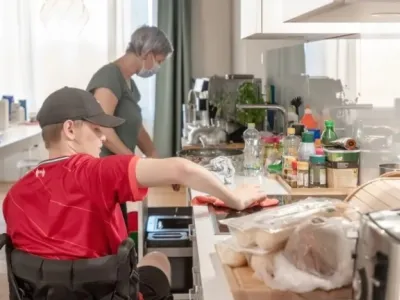 Junger Rollstuhlfahrer beim Kochen