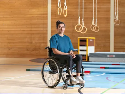 Giulia Damiano est assise dans son fauteuil roulant dans une salle de gymnastique.