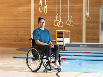 Giulia Damiano est assise dans son fauteuil roulant dans une salle de gymnastique.