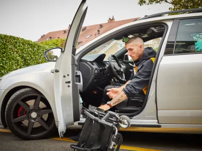 Louka Réal steigt aus seinem Auto aus und klappt den Rollstuhl auf.