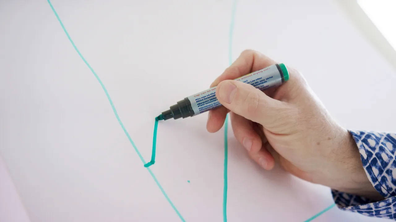 Hand schreibt auf eine Flipchart