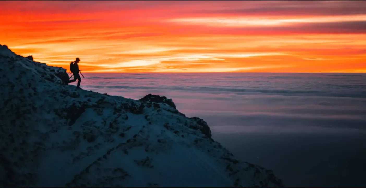 Bergsilhouette mit Wanderer im Sonnenuntergang