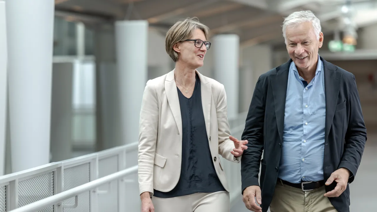 Silvia Schibli, Chefärztin Handchirurgie, und ihr Vorgänger Jan Fridén gehen nebeneinander einen Gang im Schweizer Paraplegiker-Zentrum entlang.