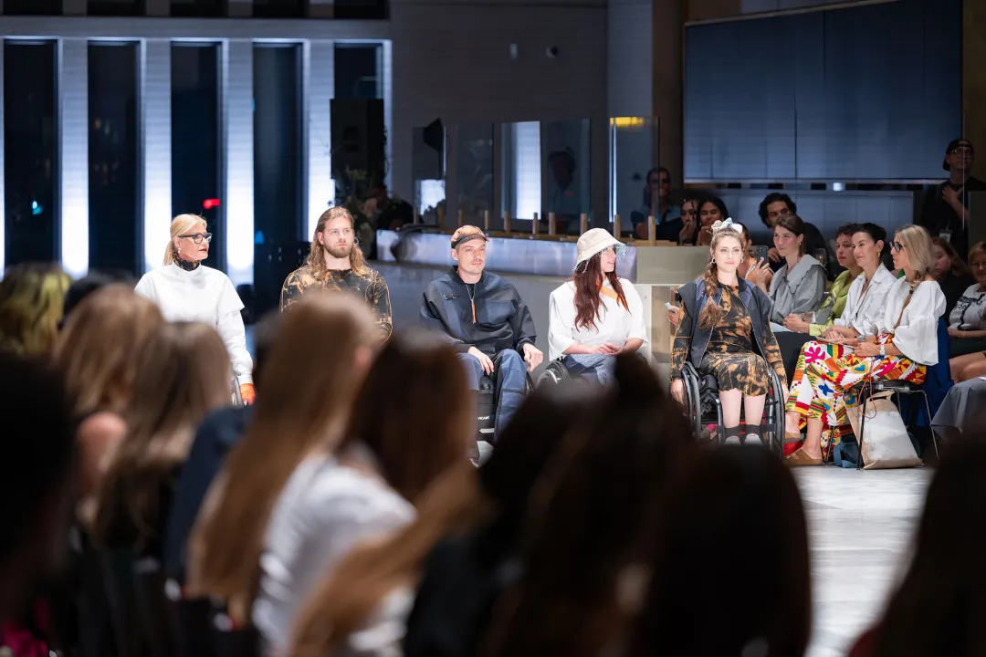 Modeschau mit rollstuhlfahrenden Models die inklusive Mode tragen.