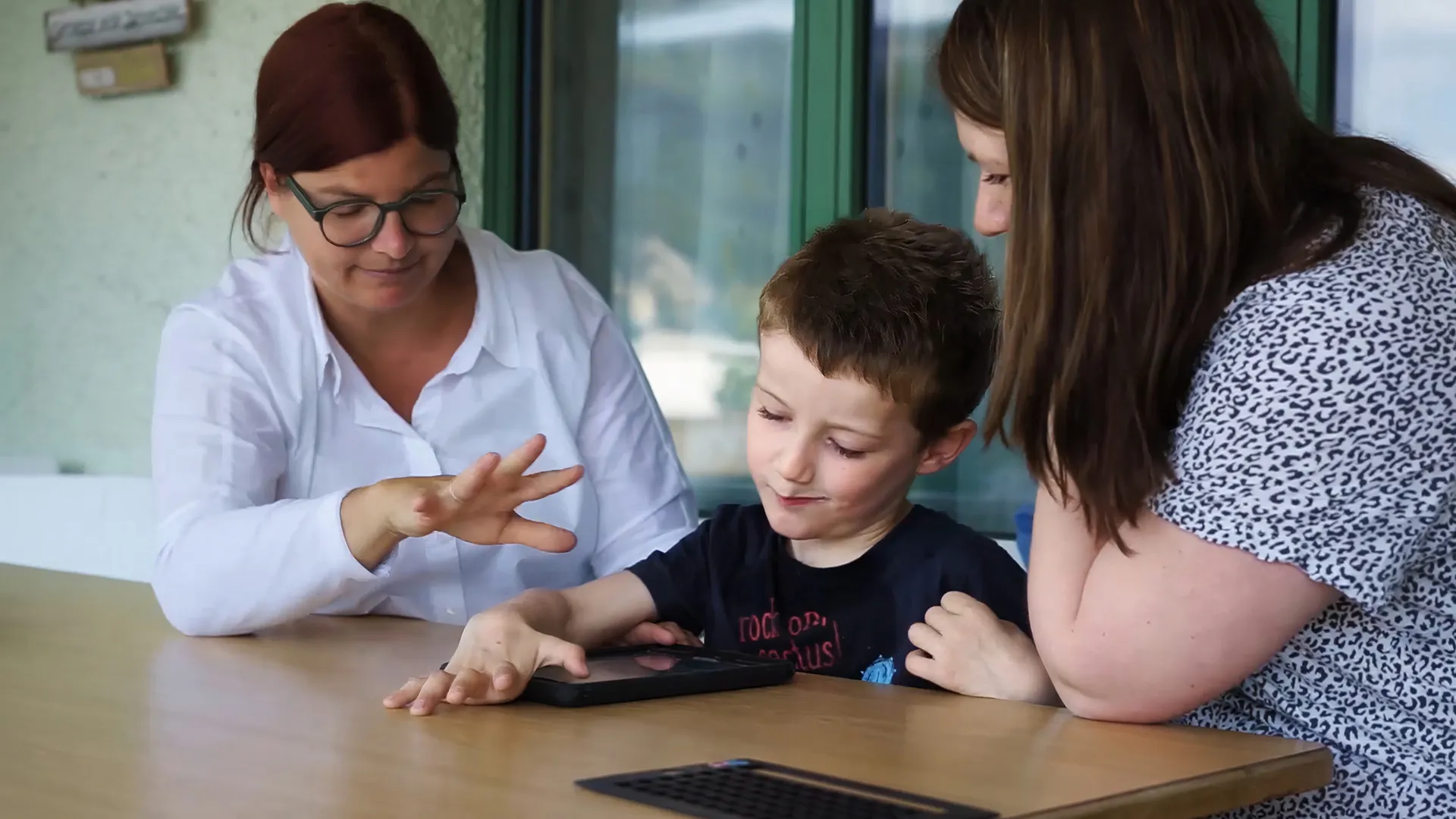 Beraterin von Active Communication erklärt Elilas Heeb und seiner Mutter neue Funktionen auf dem Talker