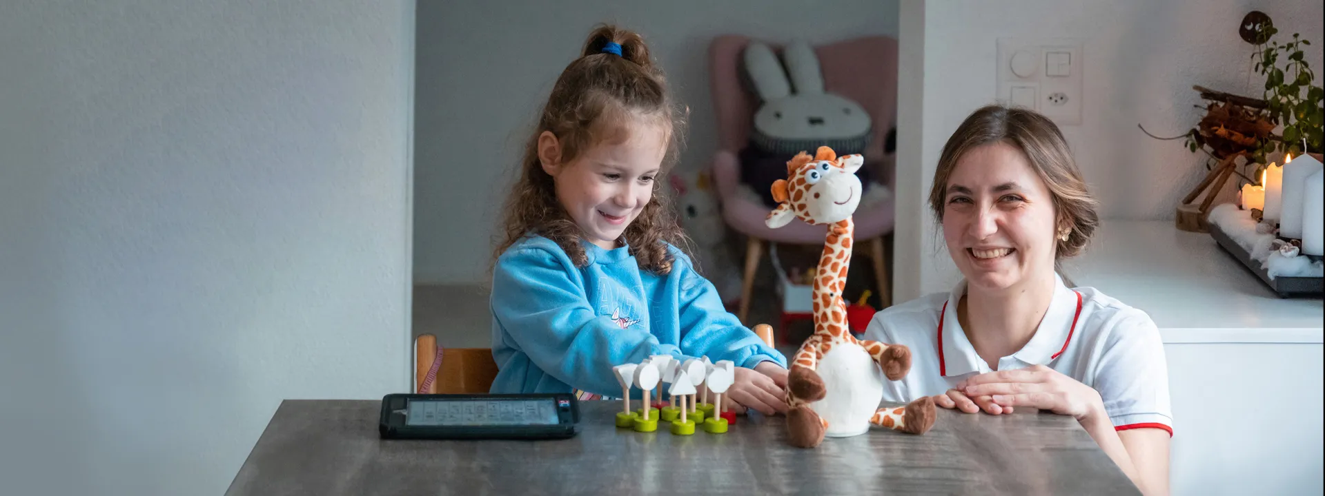 Mia Schuler spielt mit sprechneder Giraffe zusammen mit Beraterin Hannah