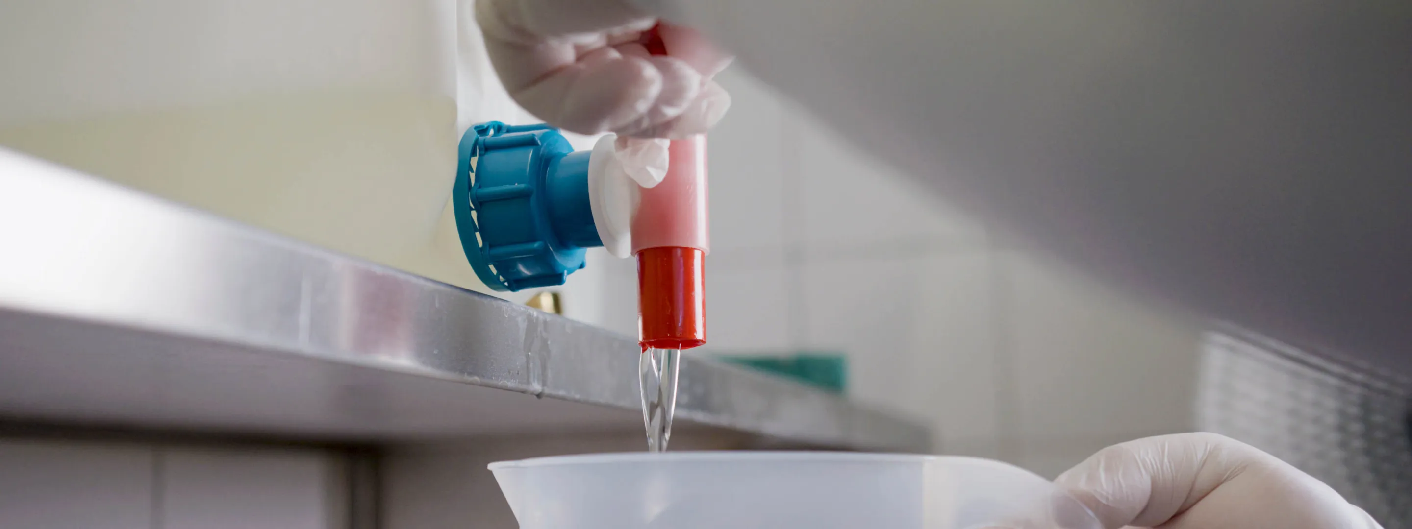 Hand öffnet Hahn Abfüllen eines Reinigungsmittels