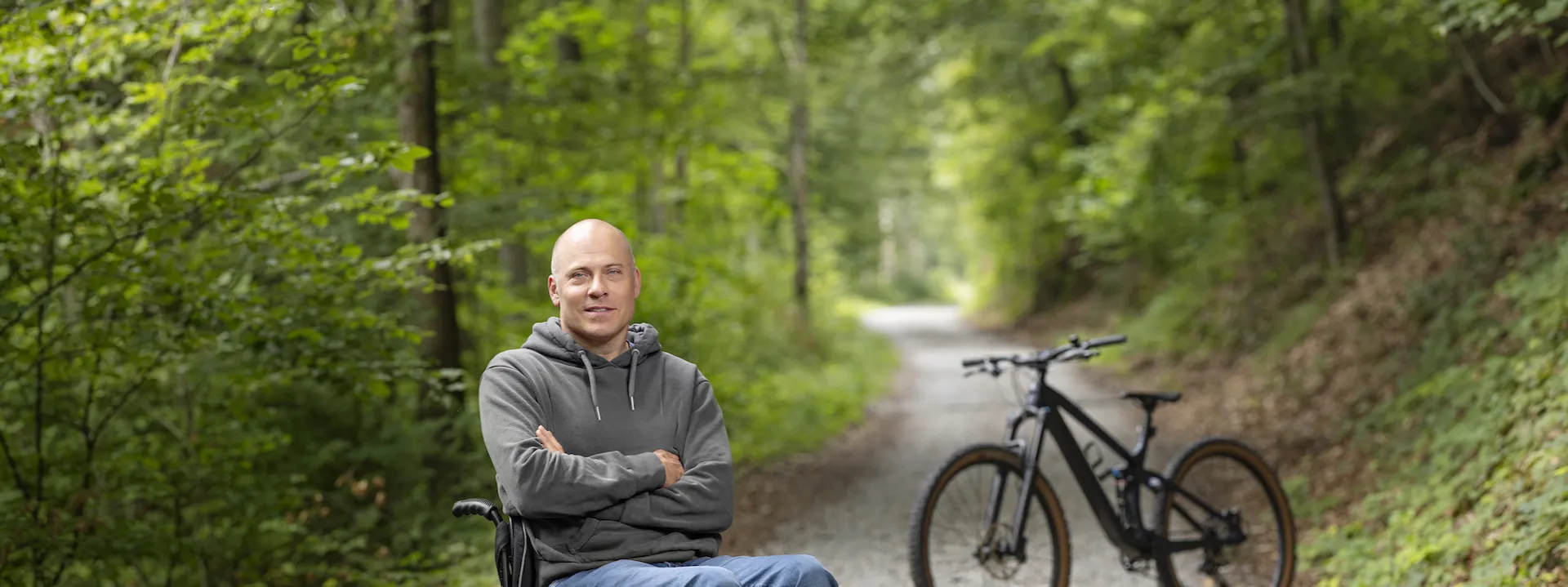 Sebastian Tobler est assise dans son fauteuil roulant dans la foret.