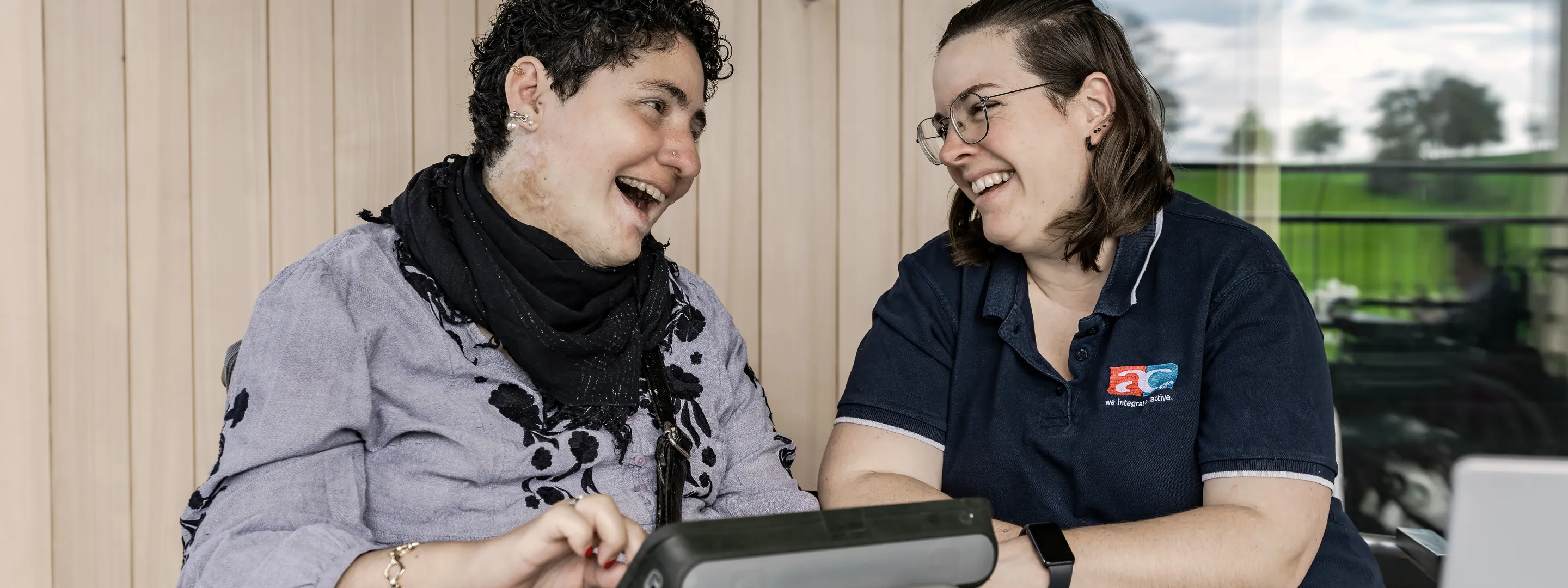 AC Beraterin berät Kundin mit Kommunikationsgerät