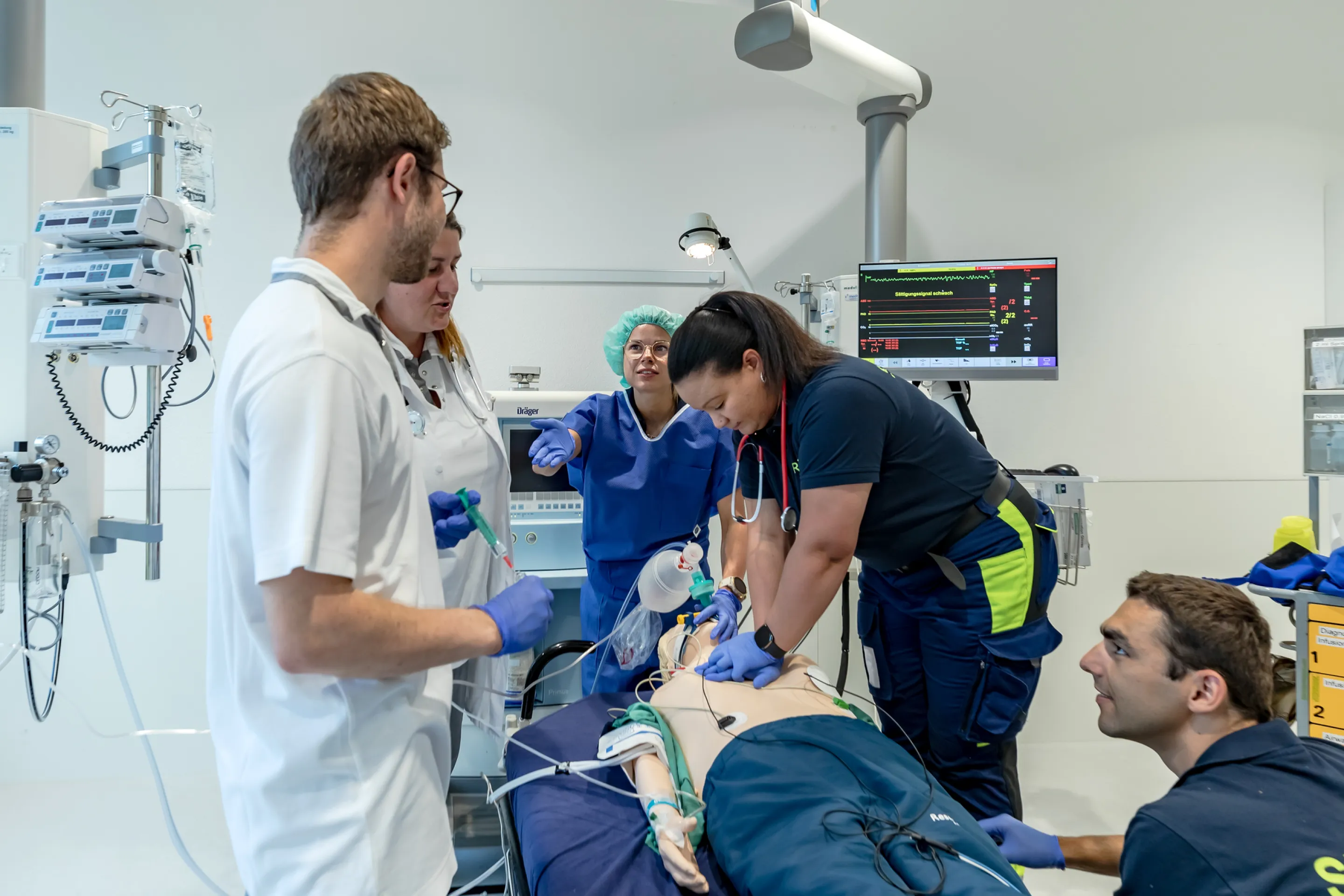 Medical team treating patient on hospital bed with monitoring equipment