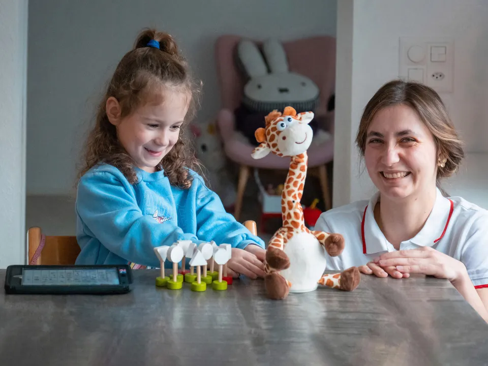 Mia Schuler spielt mit sprechneder Giraffe zusammen mit Beraterin Hannah