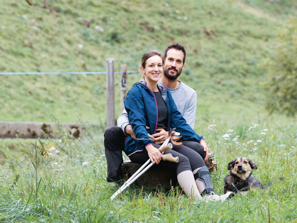 Andrea Treier und ihr Partner Andreas Signer sitzen auf einer Wiese.
