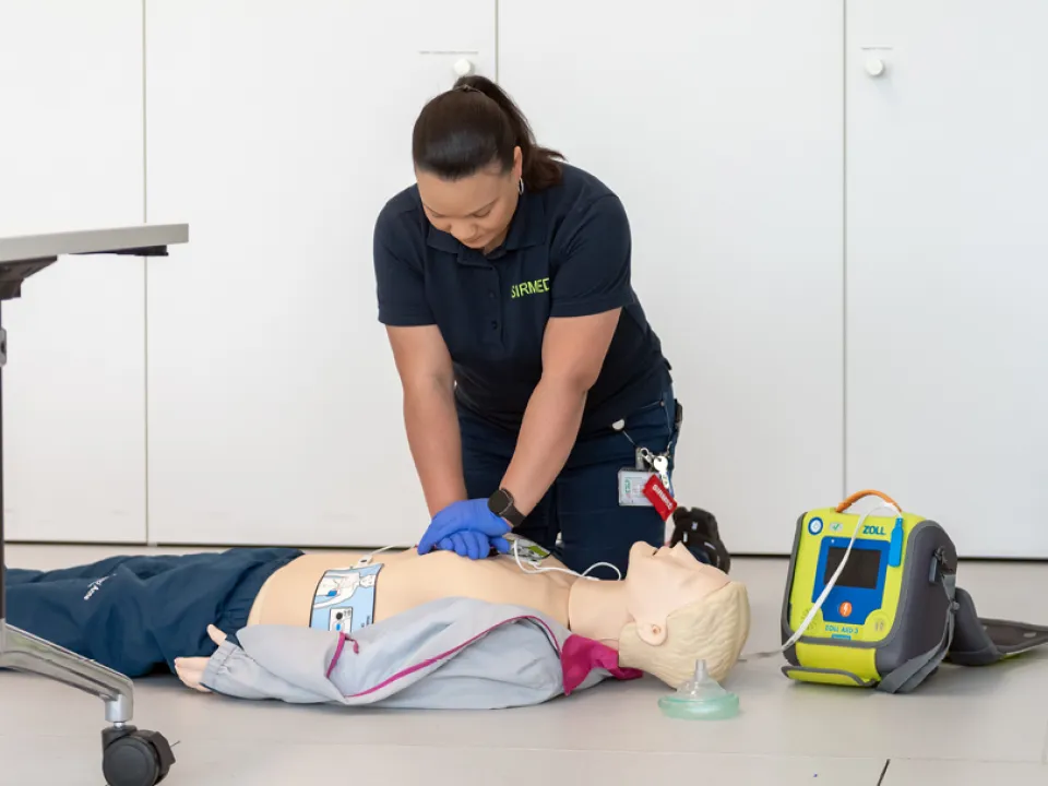 Taryn Smith zeigt anhand einer Puppe, wie Reanimation funktioniert