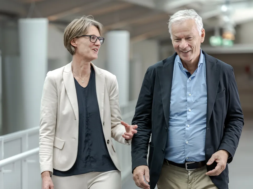 Silvia Schibli, Chefärztin Handchirurgie, und ihr Vorgänger Jan Fridén gehen nebeneinander einen Gang im Schweizer Paraplegiker-Zentrum entlang.