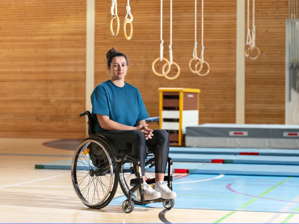 Giulia Damiano est assise dans son fauteuil roulant dans une salle de gymnastique.