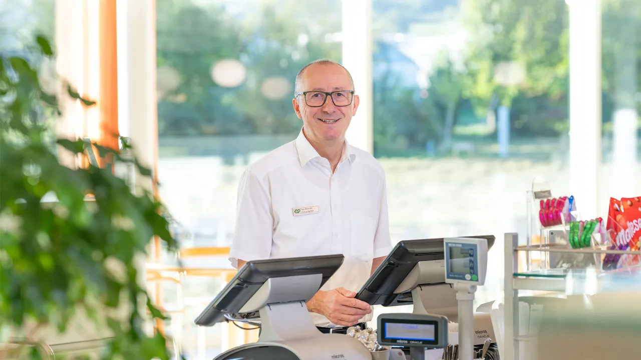 Ilidio Manuel Silva Mahado steht an der Kasse in Centro und lächelt in die Kamera.