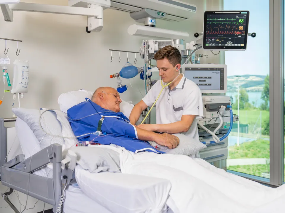 A medical professional examining a patient in a hospital room.