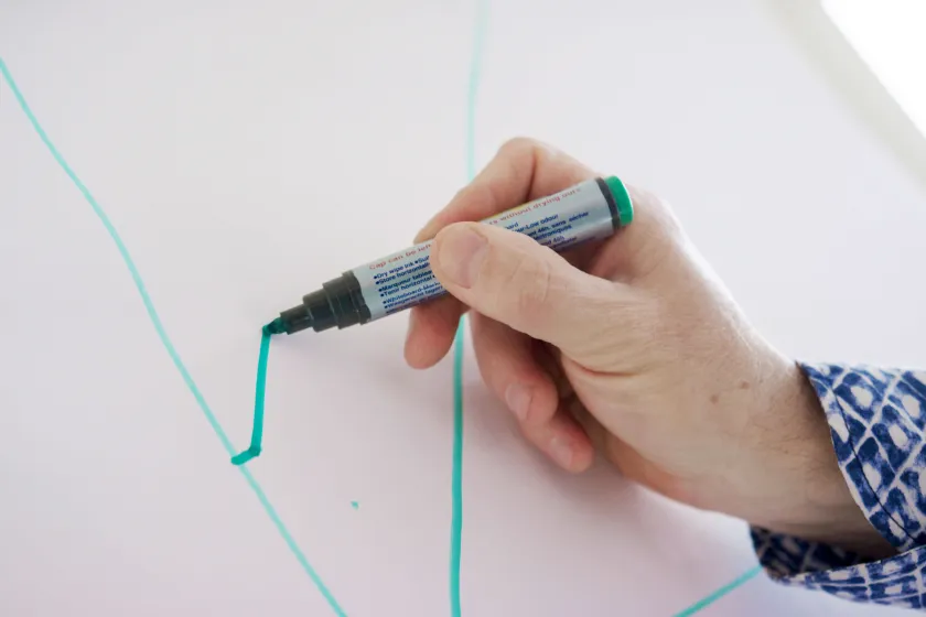 Hand schreibt auf eine Flipchart