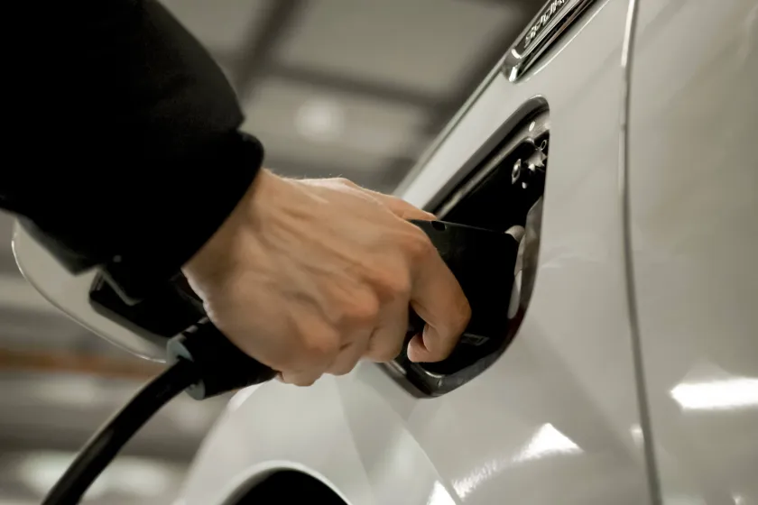 Hand tankt Fahrzeug mit Strom