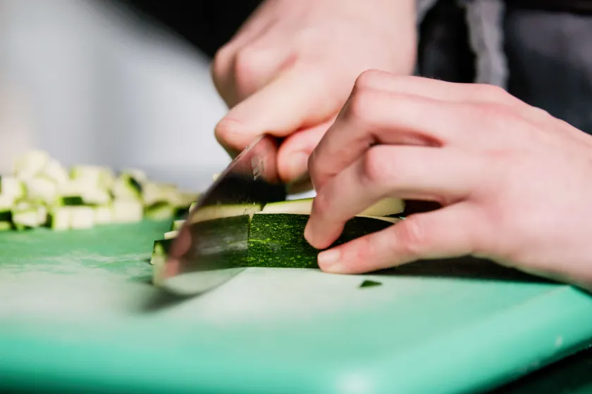 Hand schneidet Gemüse