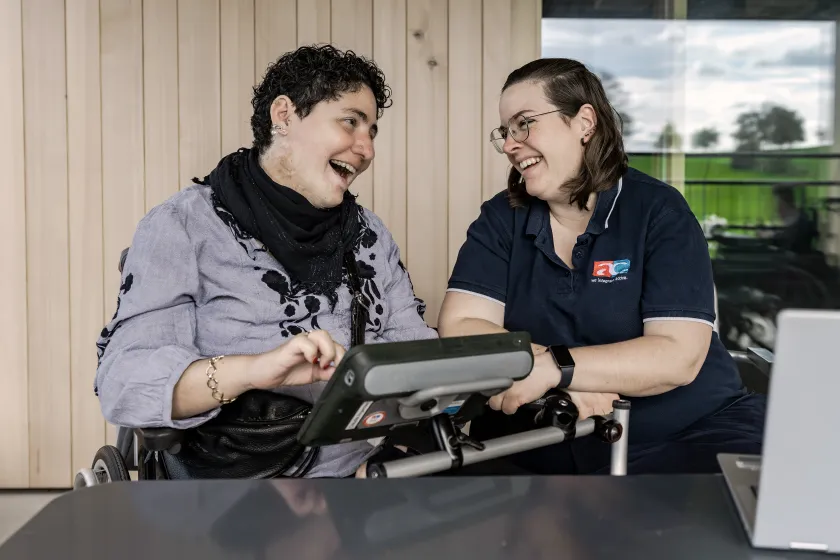 AC Beraterin berät Kundin mit Kommunikationsgerät