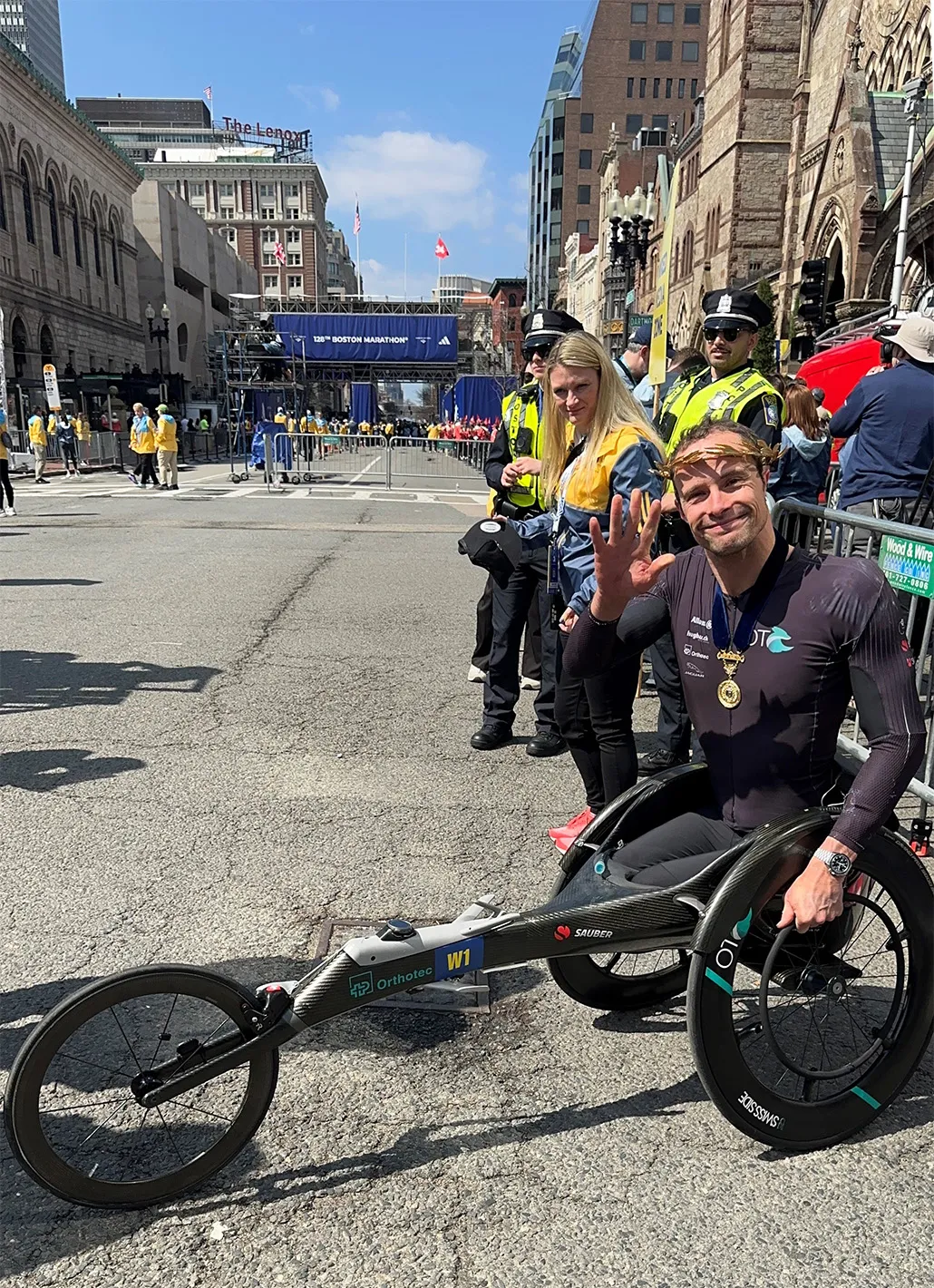 Marcel Hug portant la couronne de laurier en or devant la ligne d’arrivée du 128e marathon de Boston.