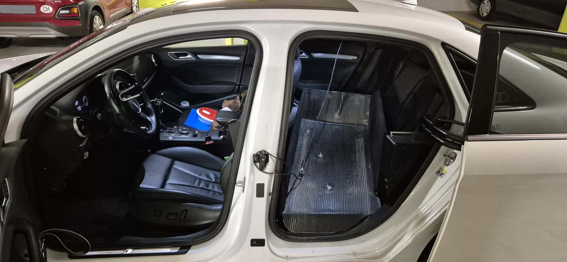 Innenansicht eines weißen Autos mit blauer Beleuchtung und geöffneter Tür.