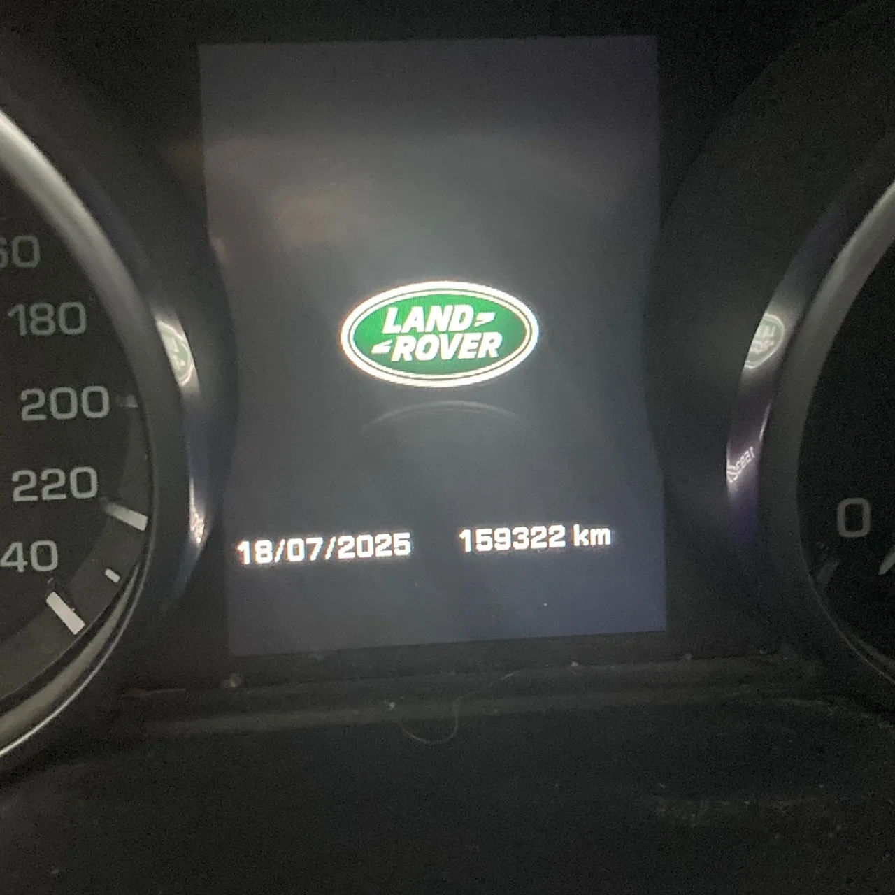 Armaturenbrett eines Land Rover mit leuchtendem Logo und Kilometerstand von 196325 km.
