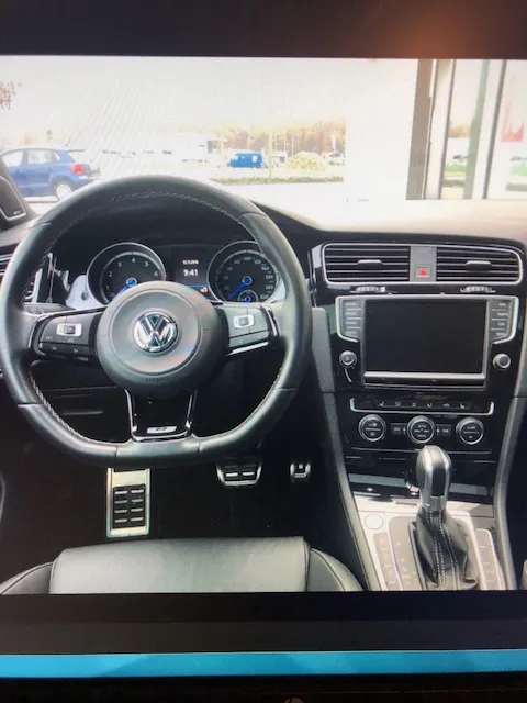 Innenraum eines Volkswagen Golf mit Lenkrad, Armaturenbrett und Mittelkonsole.