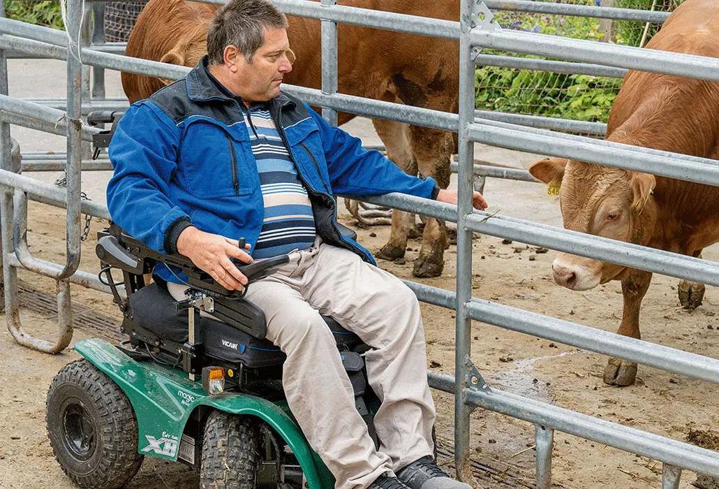 Daniel Brem vor einem Aussengehege mit Rindern.