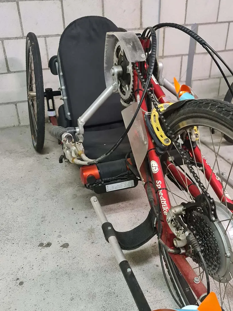 occasion-speedbike-nguyen-04.jpg Rotes Fahrrad mit Kindersitz an der Wand befestigt.