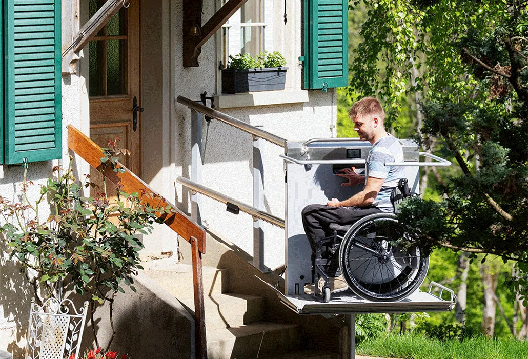 Markus Buser fährt mit seinem Treppenlift zur Eingangstüre seines Hauses.