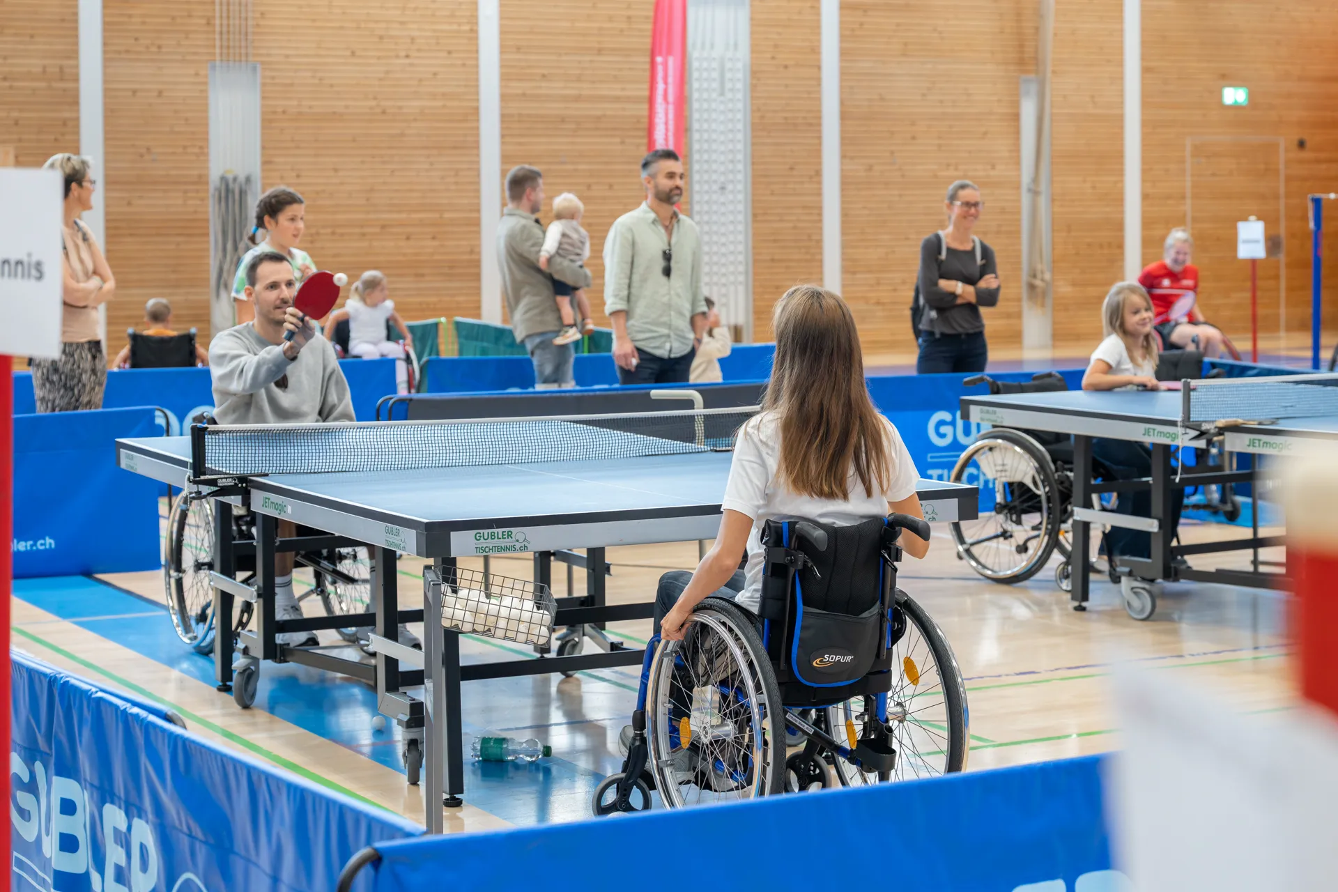 Mehrere Personen spielen Tischtenis im Rollstuhl.