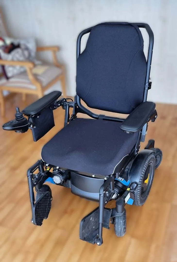Elektrischer Rollstuhl mit schwarzem Sitz und Rückenlehne, kompaktes Design für den Innenbereich.