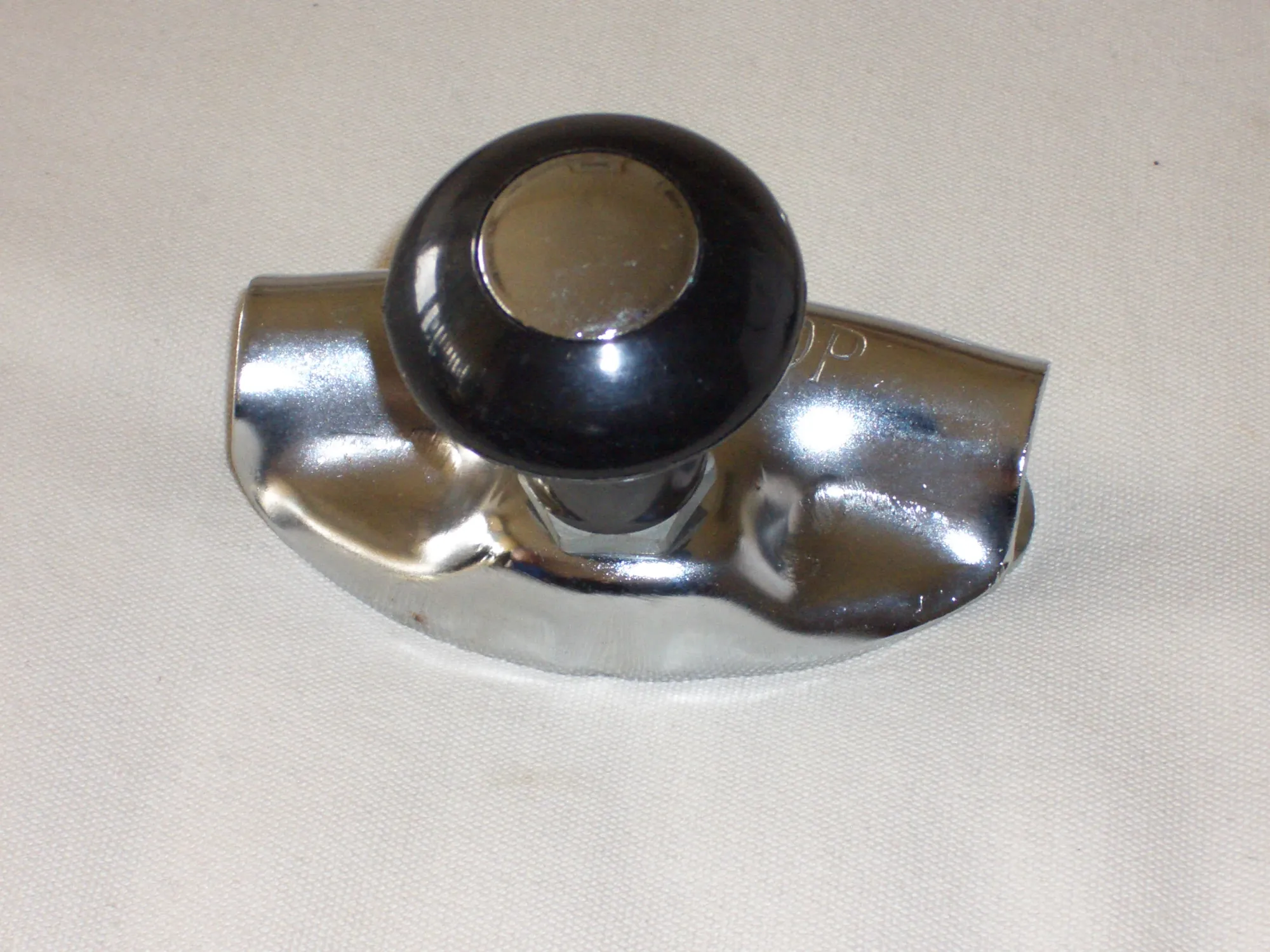 Chrome car horn with black button on polished metal base