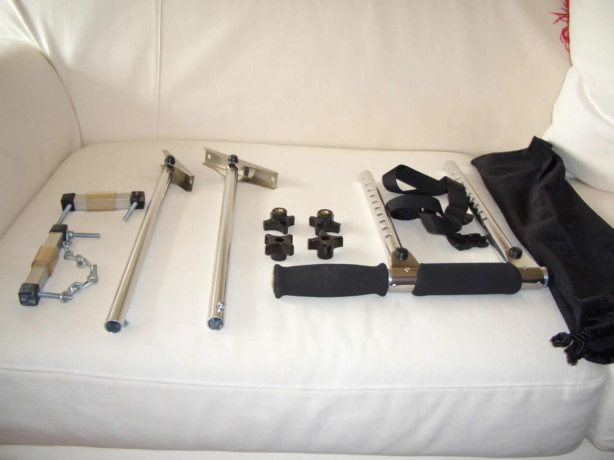 Various exercise equipment including dumbbells, resistance bands, and fitness accessories on white couch