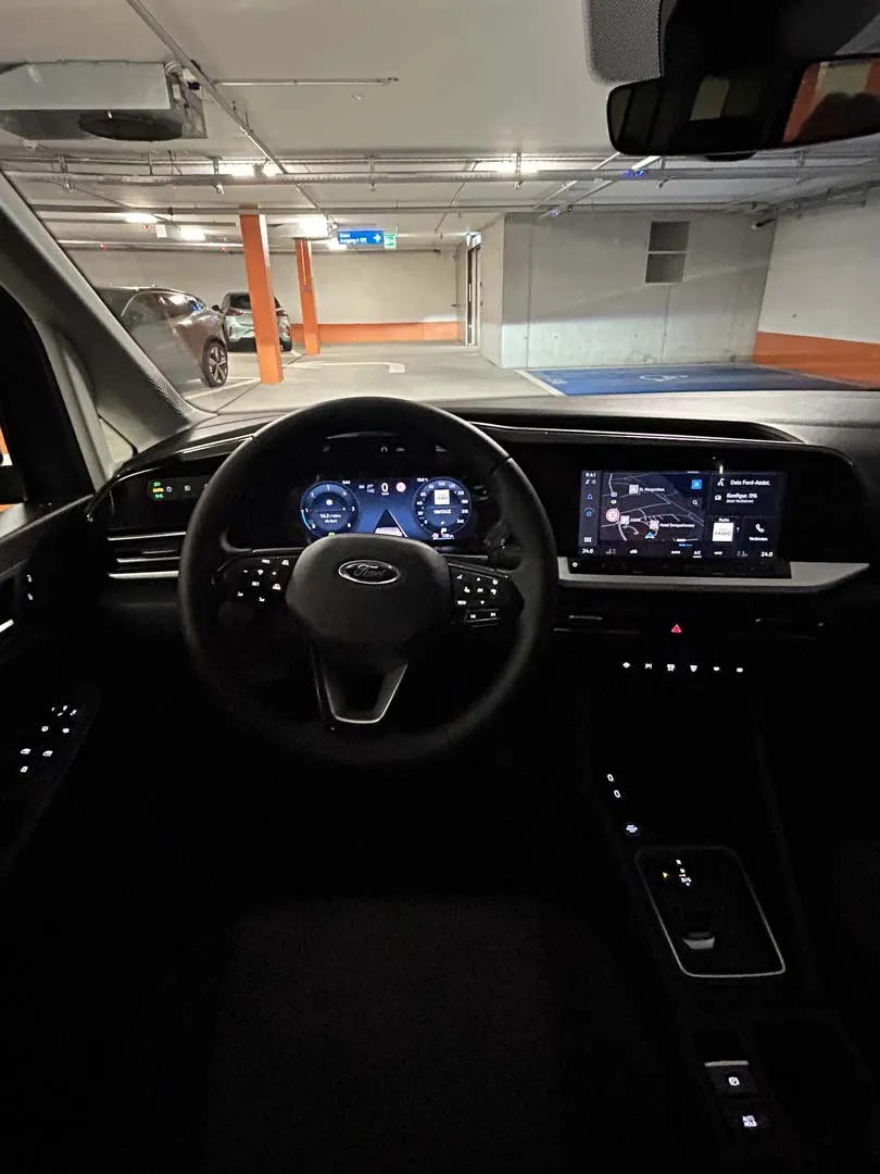 occasion-ford-tourneo-connect-blau-orthotec-05.jpg Modernes Cockpit eines Autos mit digitalem Armaturenbrett und Mittelkonsole bei Nacht