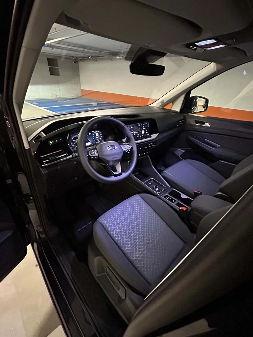 occasion-ford-tourneo-connect-blau-orthotec-07.jpg Innenansicht eines modernen Autos bei Nacht, beleuchtet mit blauem Licht.