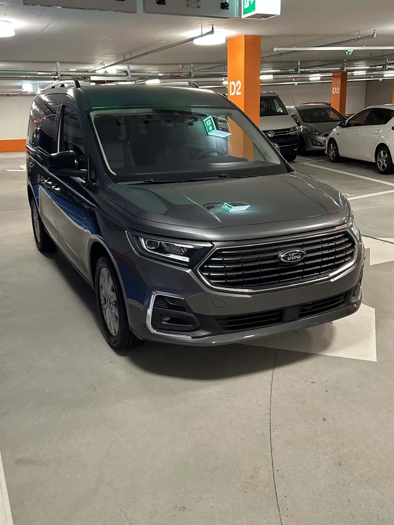 occasion-ford-tourneo-connect-grau-orthotec-04.jpg Grauer Minivan in einer Tiefgarage geparkt.