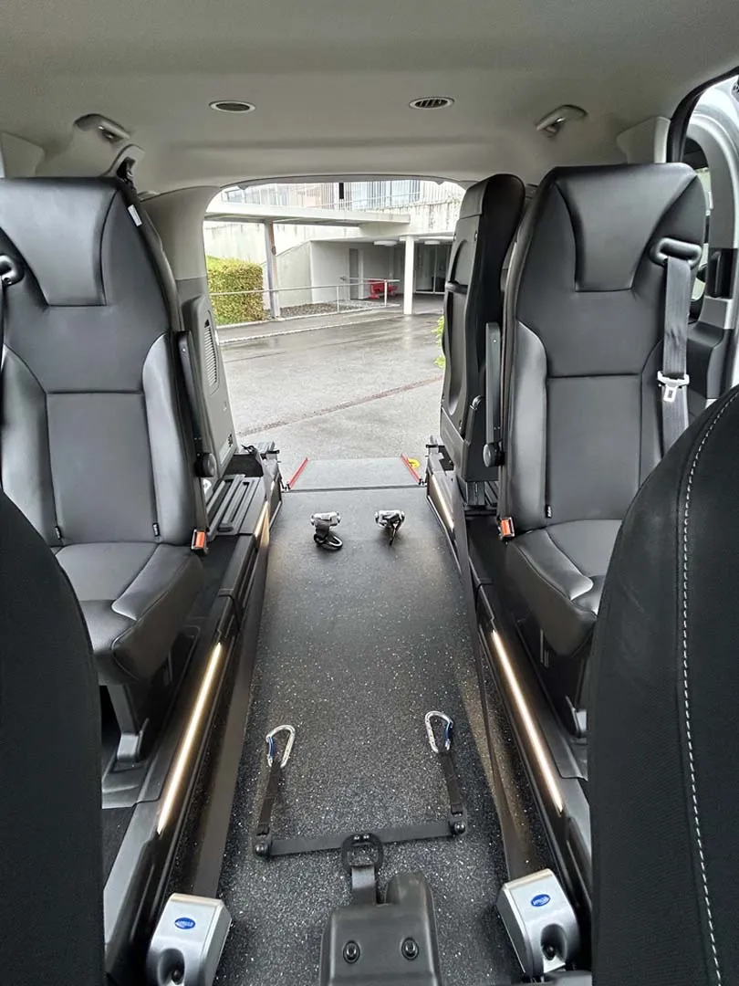 occasion-ford-tourneo-connect-silber-orthotec-08.jpg Fahrzeuginnenraum mit umgeklappten Sitzen und flacher Ladefläche für Rollstuhlzugang.