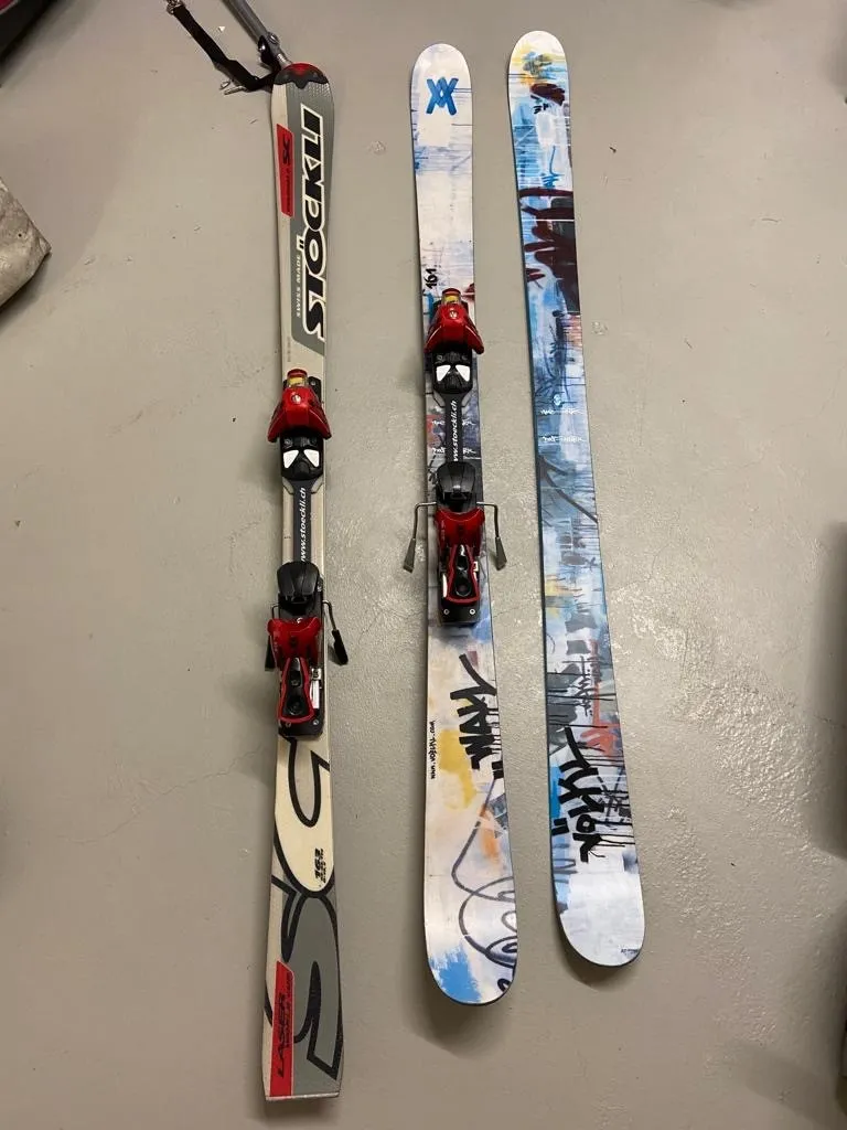 occasion-praschberger-monoskibob-sonderer-01.jpg Zwei Paar Ski und ein Paar Skistöcke auf beigem Teppich.