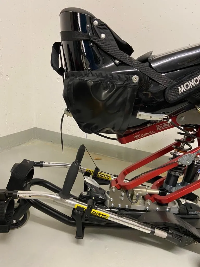 occasion-praschberger-monoskibob-sonderer-04.jpg Nahaufnahme eines roten Fahrradrahmens mit schwarzem Fahrradsattel und Pedale.
