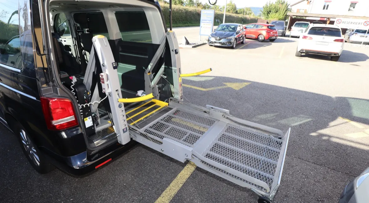 Rollstuhlgerechter Van mit ausgefahrener Rampe auf Parkplatz.
