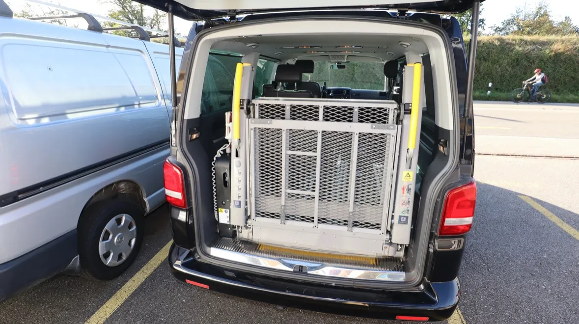 Hundetransportbox im offenen Kofferraum eines Lieferwagens.
