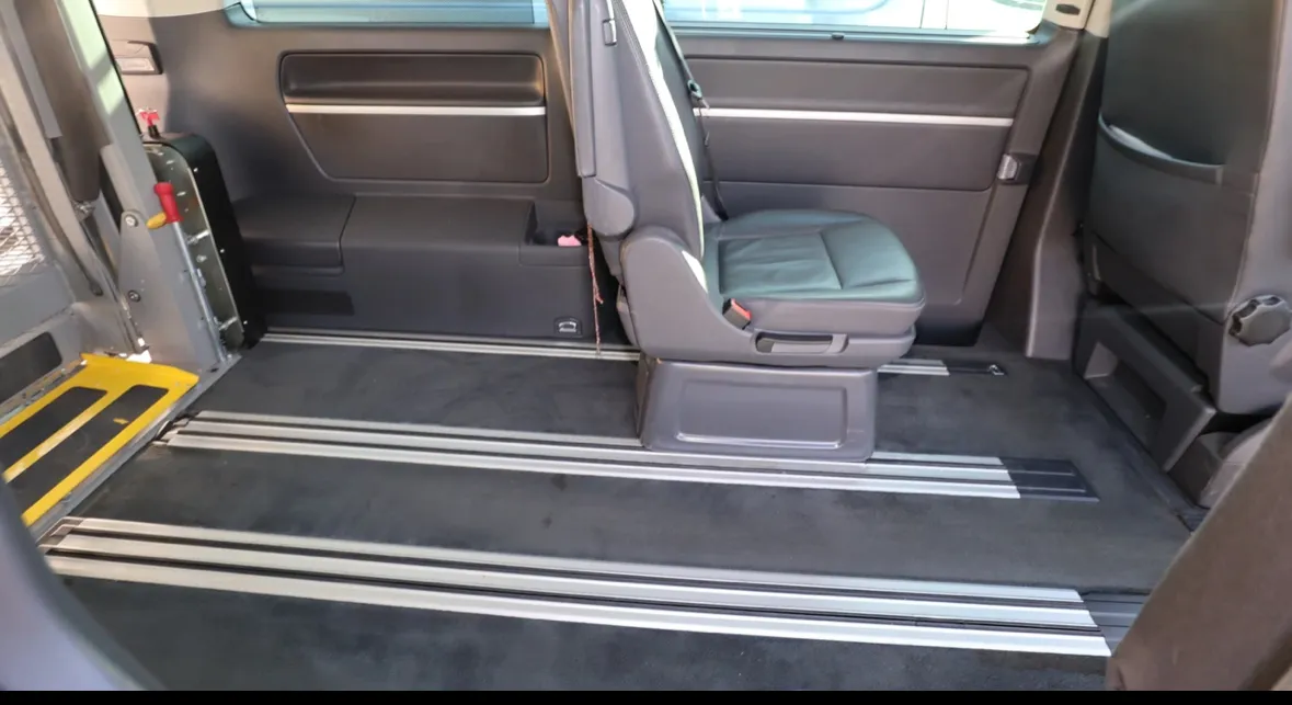 Rollstuhlgerechter Innenraum eines Vans mit herunterklappbarer Rampe und flexiblen Sitzreihen.