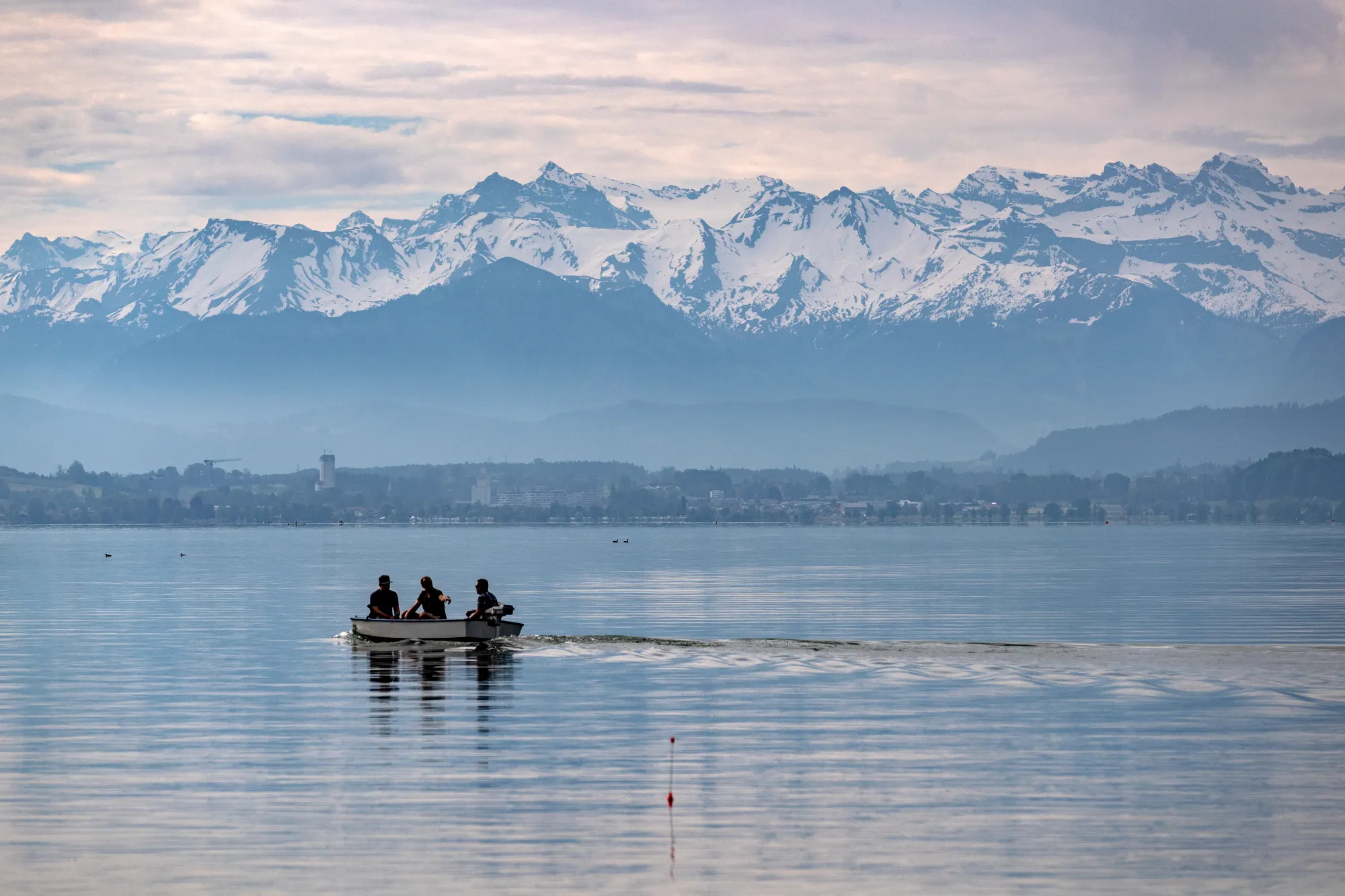 Fischerboot auf dem Vierwaldstättersee mit Bergkette im Hintergrund