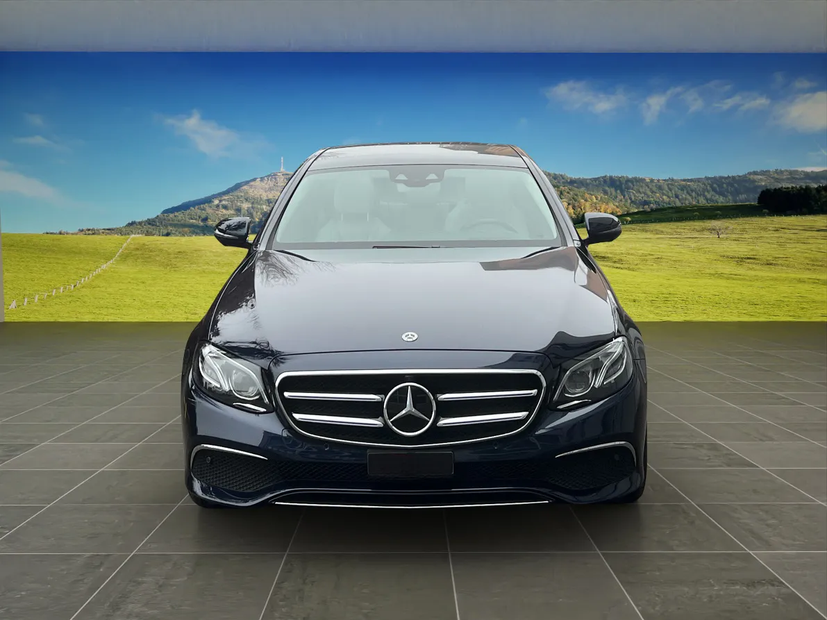 Schwarzer Mercedes-Benz auf grünem Feld unter blauem Himmel.