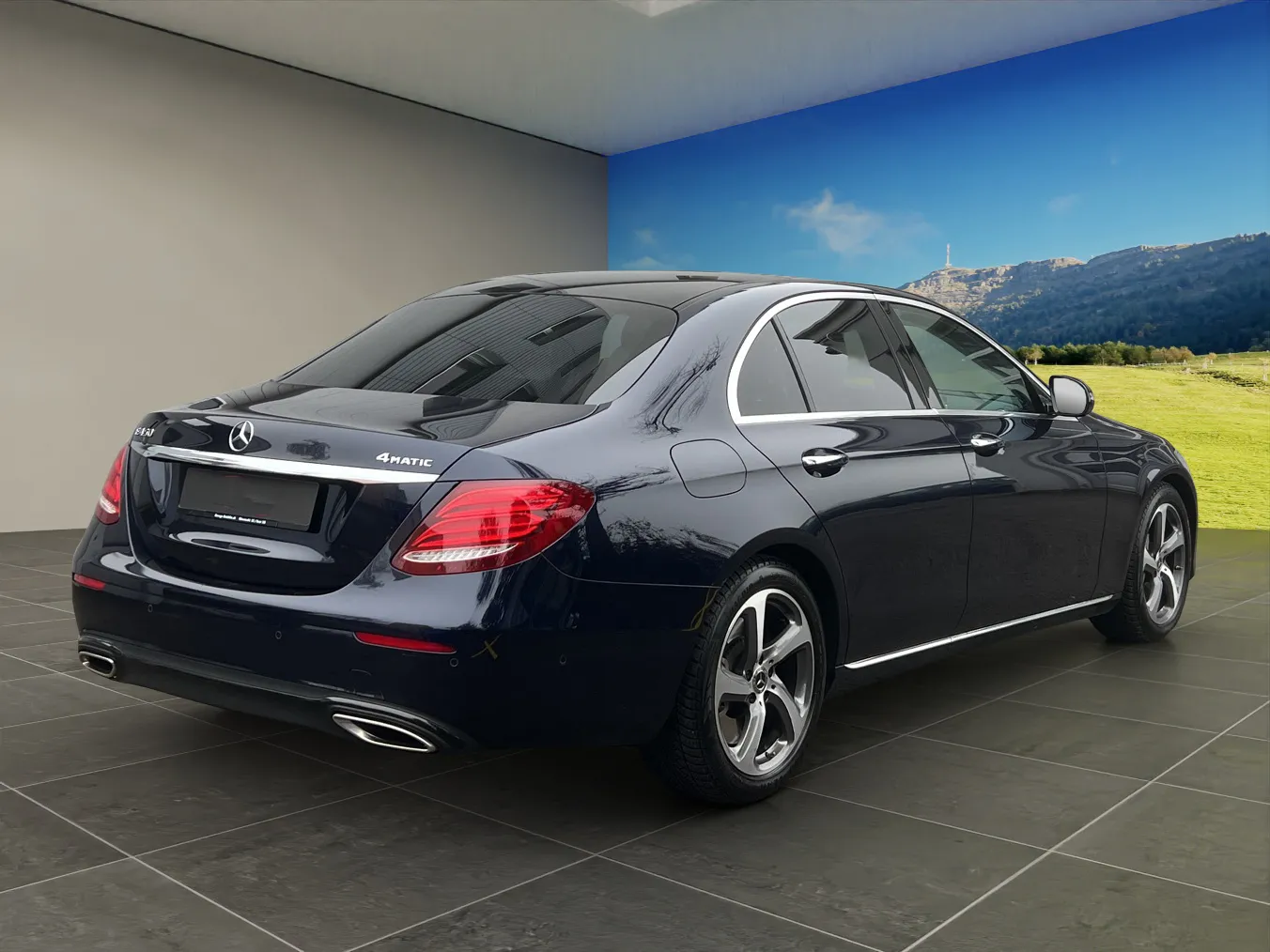Schwarzer Mercedes-Benz C-Klasse in einem Ausstellungsraum mit Berglandschaft im Hintergrund.