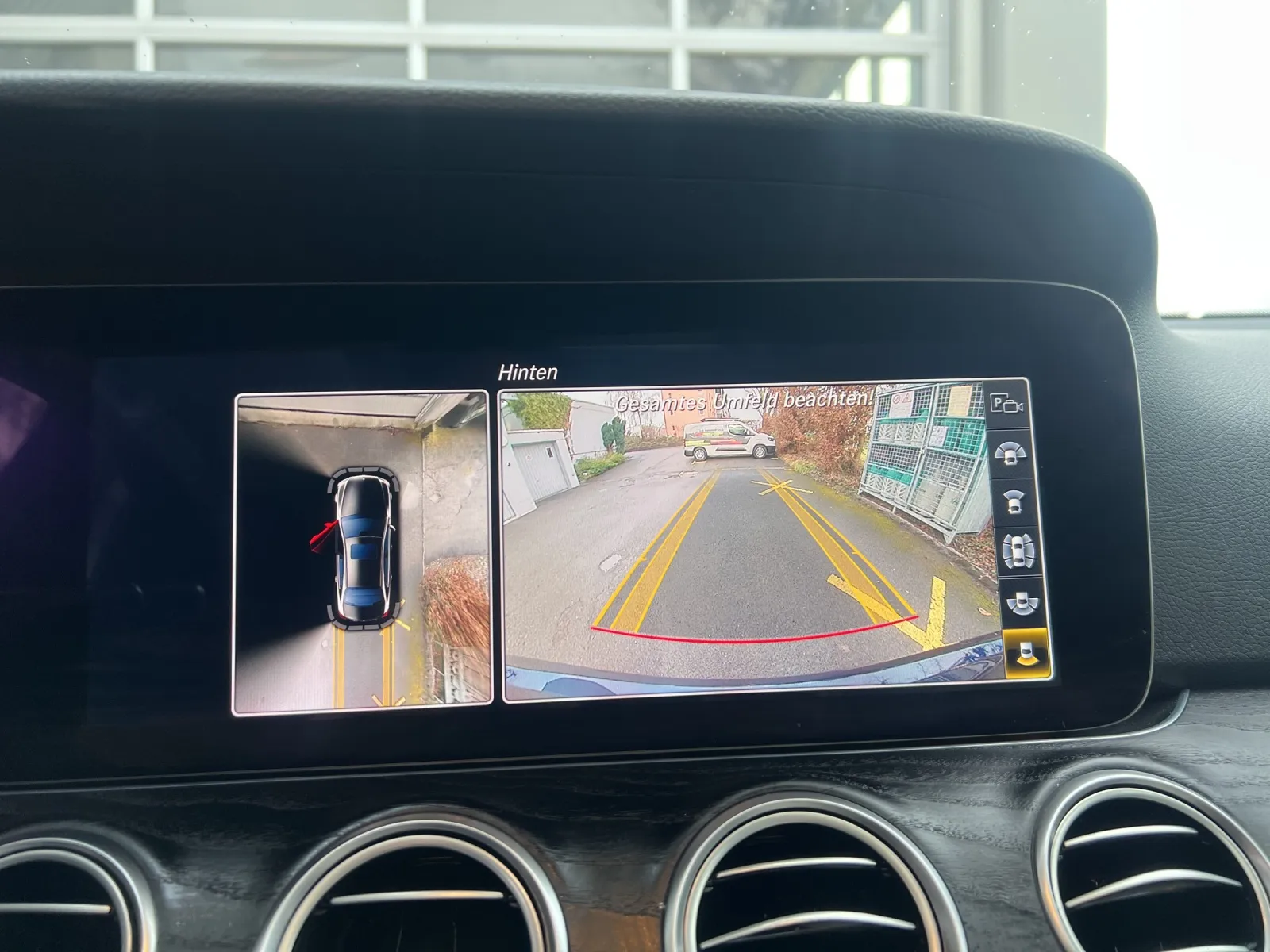 Fahrzeug-Rückfahrkamera mit Seitenansicht und Leitlinien auf dem Bildschirm des Infotainmentsystems.