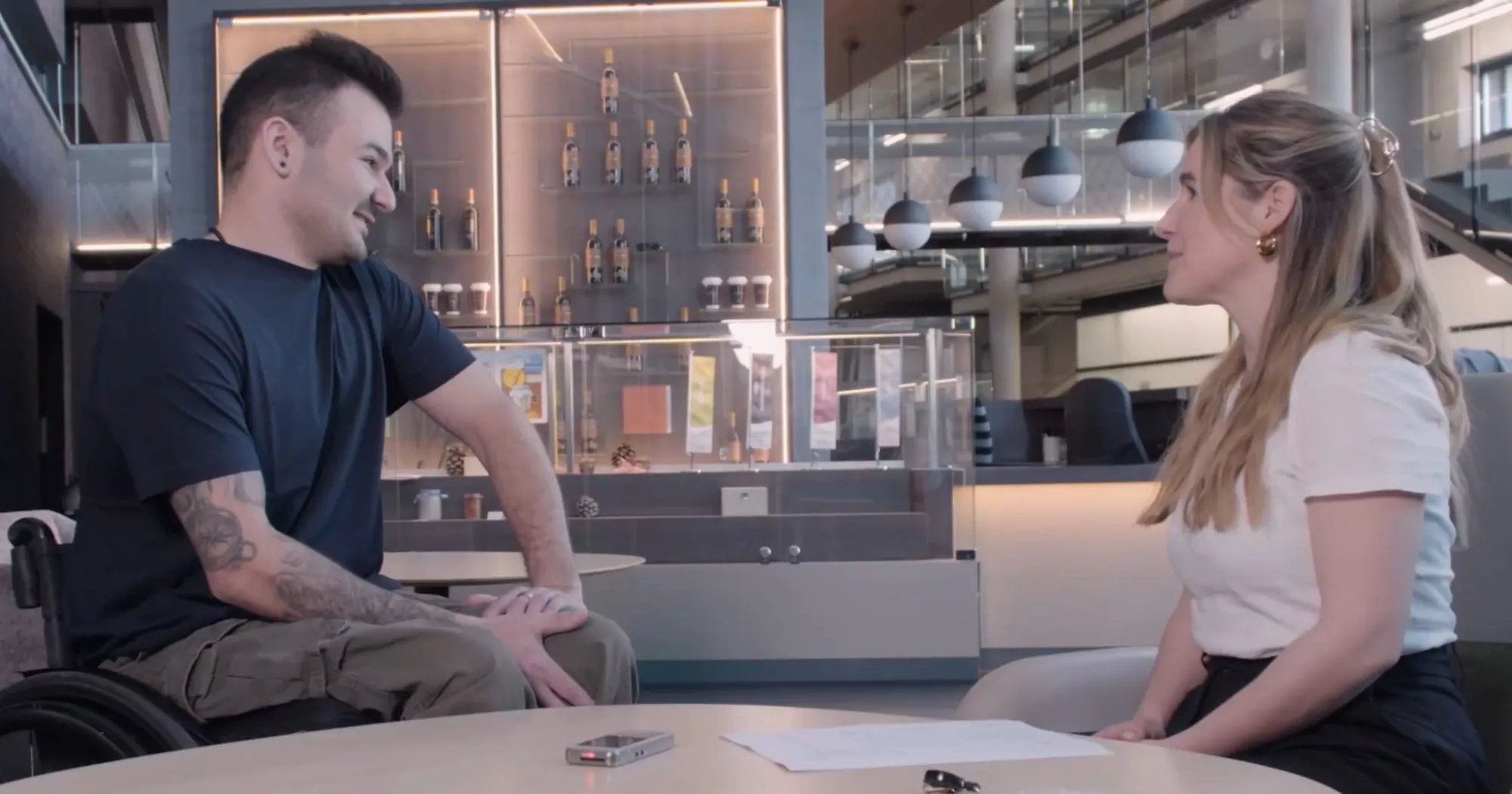 Forscherin im Gespräch mit Mann im Rollstuhl